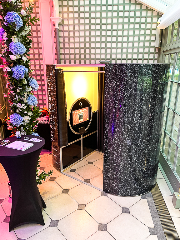 Classic enclosed photo booth with a black glitter exterior at a wedding venue