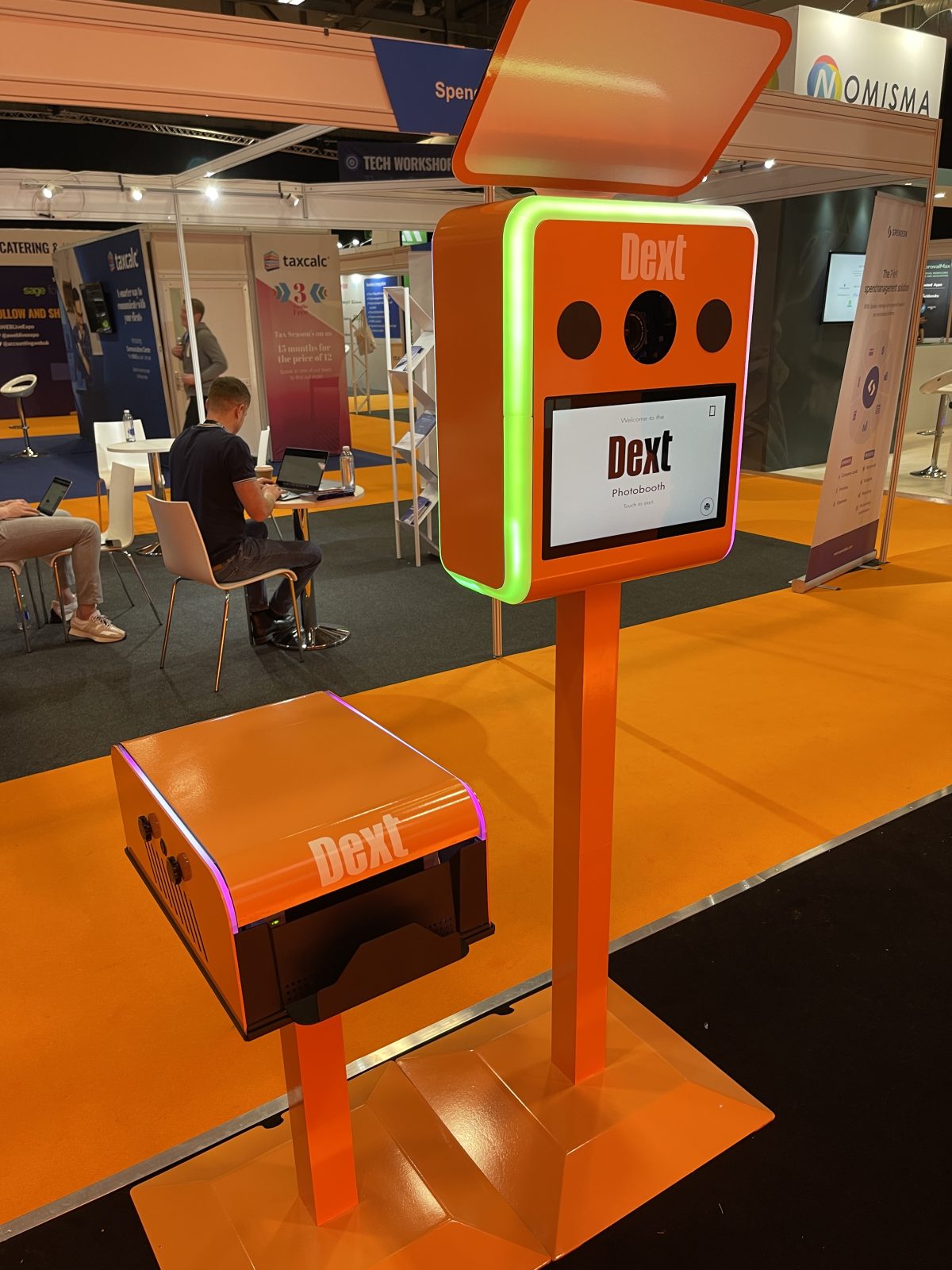 Dext branded orange photo booth on an exhibition stand
