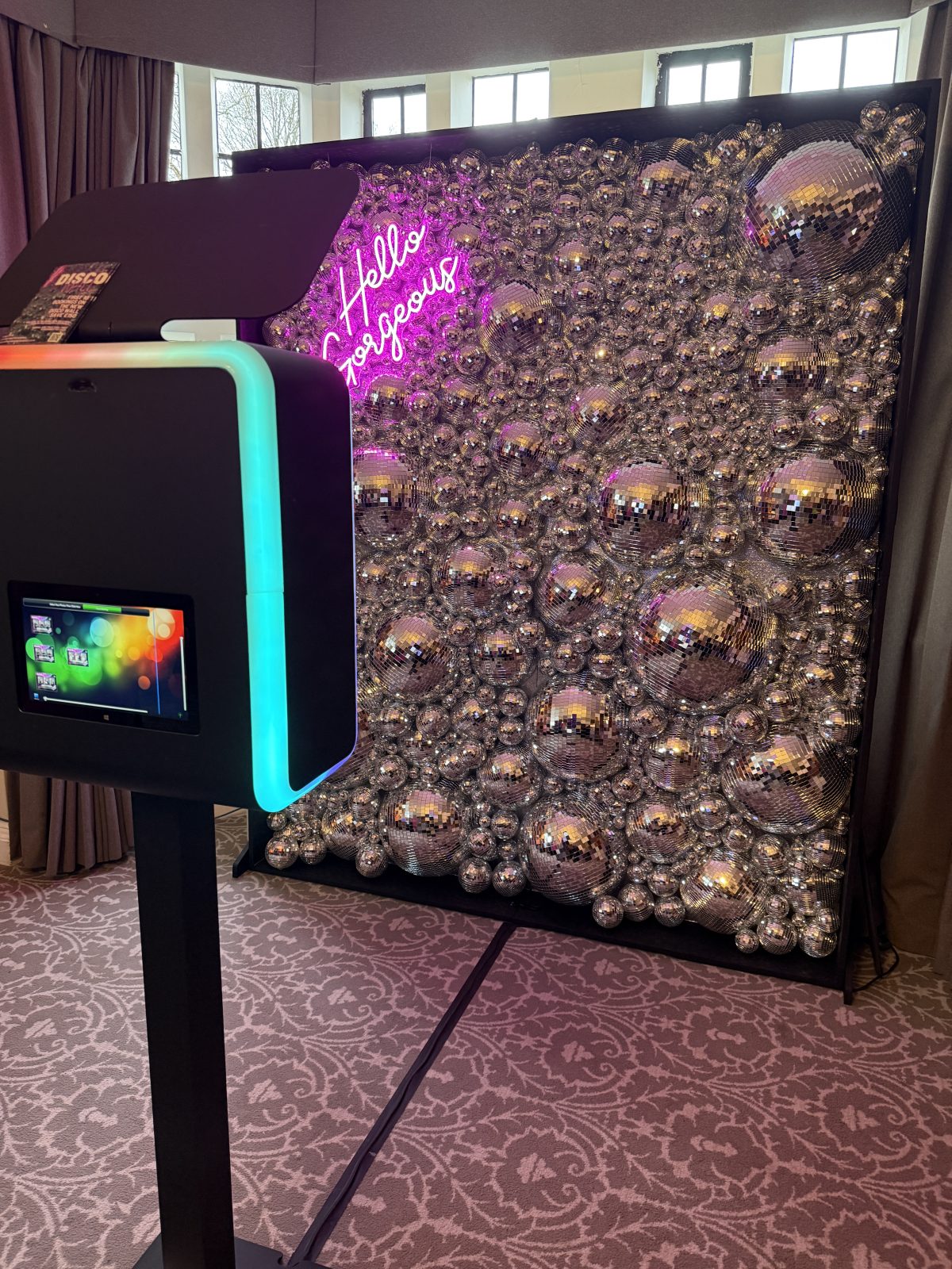 Digital photo booth with a pink neon sign and mirrored Disco Wall