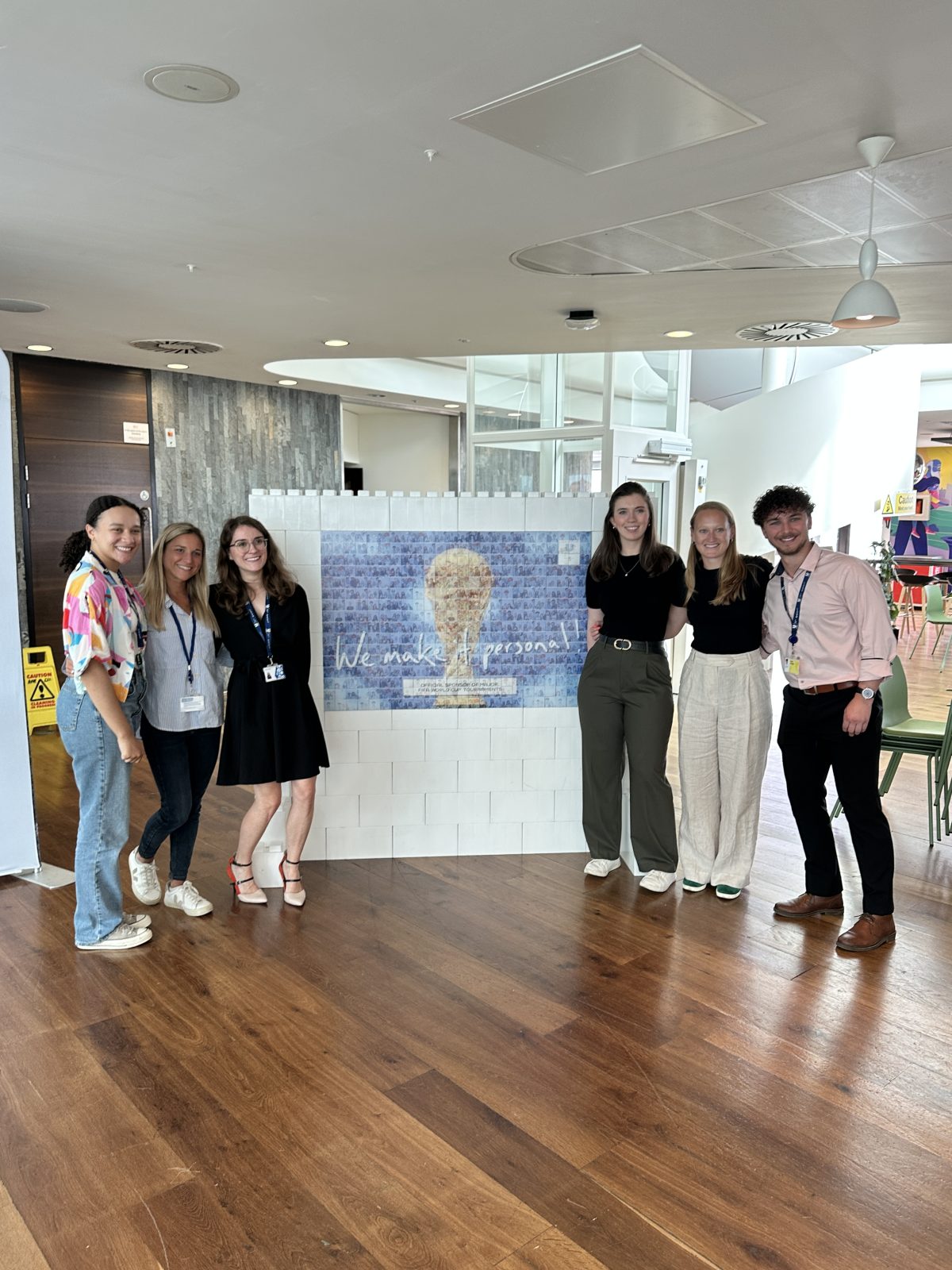 Guests posing in front of a completed corporate photo mosaic wall