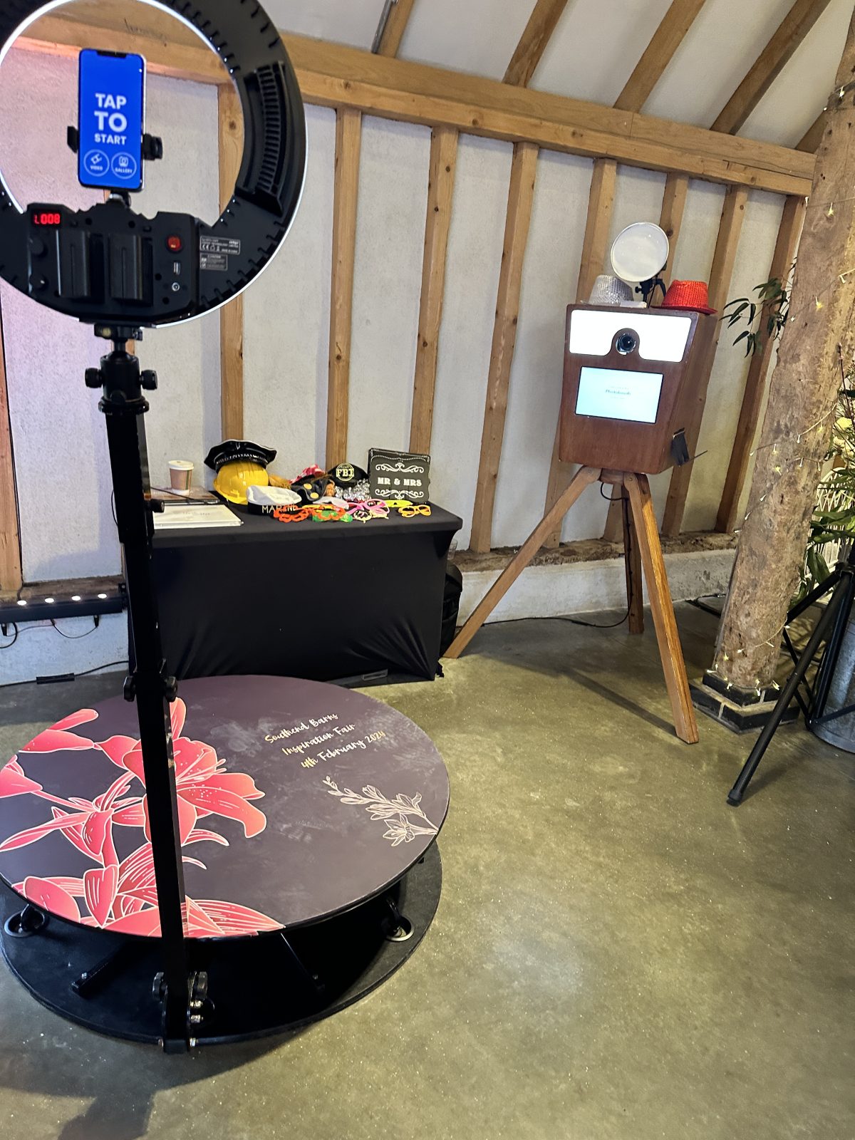 Photo booth setup with props table and a white framed mirror