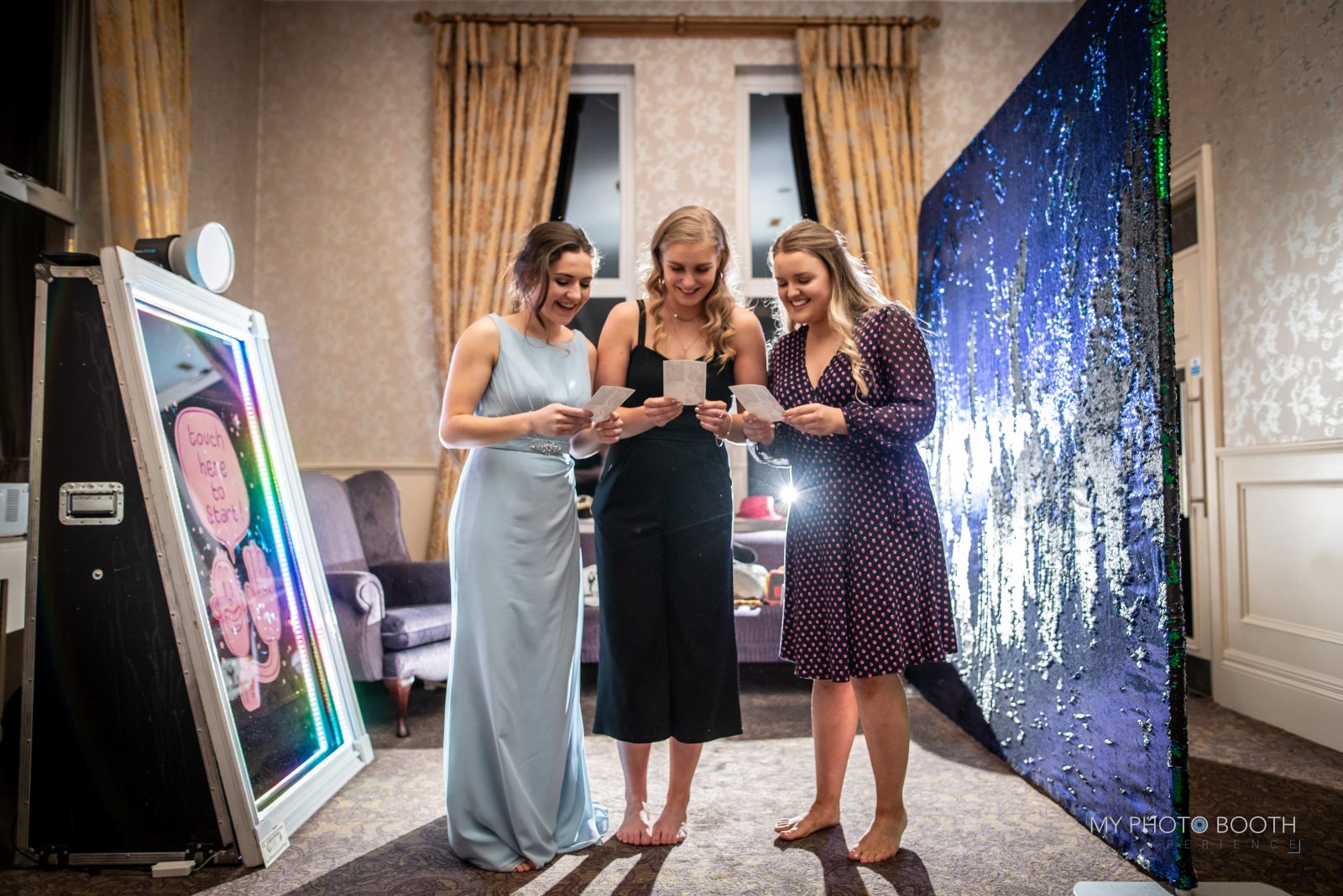 Wedding guests posing together beside a Magic Mirror photo booth